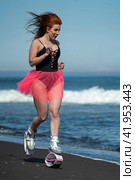 Female athlete in sports Kangoo Jumps boots, one piece swimsuit and short pink skirt running and jumping on beach during outdoors fitness workout (2022 год). Редакционное фото, фотограф А. А. Пирагис / Фотобанк Лори