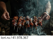 Gaucho cooking the meat on the fire, making the barbecue on the coals, Photos and menus of cafes and restaurants, Magazines. Стоковое AI-изображение, AI-художник Ирина Ручушкина / Фотобанк Лори
