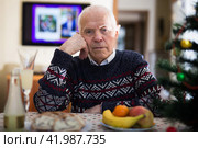 Portrait of tired lonely elderly man at the dinner table during christmas celebration. Стоковое фото, фотограф Татьяна Яцевич / Фотобанк Лори