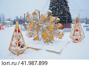 Petrozavodsk, Russia, January 10 2024: Small architectural forms in the form of luminous cones and a large cone, made of garlands and light bulbs. Festive decoration of city streets and squares. Xmas. Редакционное фото, фотограф Юлия Петровская / Фотобанк Лори