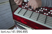 The man fasten with screws the right cover of the button accordion. Using a screwdriver. Bayan repair and maintenance. Стоковое видео, видеограф Vadzim Yakubovich / Фотобанк Лори
