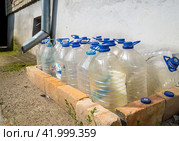 Пустые бутылки подготовлены для сбора дождевой воды из водостока (2023 год). Редакционное фото, фотограф Вячеслав Палес / Фотобанк Лори