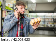 man talking on smartphone about purchasing of yogurts. Стоковое фото, фотограф Яков Филимонов / Фотобанк Лори