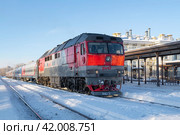 Пассажирский поезд с тепловозом ТЭП-70 на станции Рыбинск солнечным январским днем (2024 год). Редакционное фото, фотограф Виктор Карасев / Фотобанк Лори