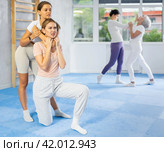 Young woman performing chokehold on female partner during self-defense training. Стоковое фото, фотограф Яков Филимонов / Фотобанк Лори