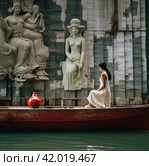 a woman in a red skirt is sitting in a boat with an airplane on the dock. Стоковое AI-изображение, AI-художник Юлия Гапеенко / Фотобанк Лори