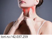 Sore throat, woman with pain in neck, gray background. Стоковое фото, фотограф Станислав Тарко / Фотобанк Лори