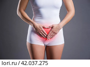 Woman with abdominal pain, stomachache on gray background. Стоковое фото, фотограф Станислав Тарко / Фотобанк Лори