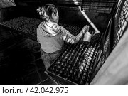Kathmandu, Nepal - November 22, 2015: Old woman prepares incense butter candles. Boudhanath stupa in Kathmandu, Nepal. Black and white image. Редакционное фото, фотограф VittoriaChe / Фотобанк Лори
