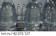 Синие пластиковые бутылки с водой движутся по конвейеру. Камера следит за бутылками. Завод по производству минеральной воды и безалкогольных напитков. Стоковое видео, видеограф Воловодов Владимир / Фотобанк Лори