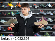 Guy examine view item of autumn comfortable trecking shoes. Стоковое фото, фотограф Яков Филимонов / Фотобанк Лори