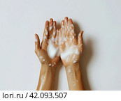 Women's hands with cosmetic cleansing white foam applied to them. Стоковое AI-изображение, AI-художник Ярославский Максим / Фотобанк Лори