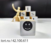 Wooden cubes in a column and a row with white signs with a smiley sign, an arrow, a percentage. The concept of positivism. Positive thinking leads to the achievement of results and profits. Стоковое фото, фотограф Кривошеина Елена Леонидовна / Фотобанк Лори