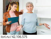 Angry female householder demanding older woman to pay off debt. Стоковое фото, фотограф Яков Филимонов / Фотобанк Лори