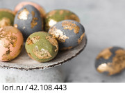 Beautiful Easter eggs with a golden coating were laid on a steel concrete plate on a gray background. The concept of happy Easter 2024. Стоковое фото, фотограф Photojuli / Фотобанк Лори