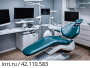 Close-up dental equipment in dentist office in new modern stomatological clinic room. Background of dental chair and accessories used by dentists in blue, medic light. Copy space, text place. Стоковое AI-изображение, AI-художник Aleksandr Golubev / Фотобанк Лори