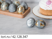 Stylish grey Easter eggs made of marble and concrete with a golden potala on a grey background. Coloring eggs with natural dye karkade tea. . The concept of a happy Easter. Стоковое фото, фотограф Photojuli / Фотобанк Лори