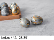 Stylish grey Easter eggs made of marble and concrete with a golden potala on a grey background. Coloring eggs with natural dye karkade tea. . The concept of a happy Easter. Стоковое фото, фотограф Photojuli / Фотобанк Лори