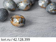 Stylish grey Easter eggs made of marble and concrete with a golden potala on a grey background. Coloring eggs with natural dye karkade tea. . The concept of a happy Easter. Стоковое фото, фотограф Photojuli / Фотобанк Лори