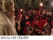Пасха 2018 года в Успенском храме Новодевичьего монастыря, Москва. Митрополит Ювеналий раздаёт благодатный огонь. Редакционное фото, фотограф Дмитрий Неумоин / Фотобанк Лори