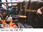 Moscow seasons. A traditional craft. Blacksmith's work with metal. Hammer and anvil. Russian traditions. Moscow. Russia (2023 год). Стоковое фото, фотограф Photojuli / Фотобанк Лори