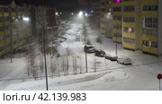 Petrozavodsk, Russia 01.12.24 Frosty winter cityscape. Snow is falling. Extreme north. White beautiful snowflakes fall. Blizzard night, parking. Trees sway in wind. Weather forecast. Utility services. (2017 год). Редакционное видео, видеограф Юлия Петровская / Фотобанк Лори