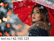 Woman under red umbrella in fabulous winter landscape. Стоковое AI-изображение, AI-художник Юрий Поздников / Фотобанк Лори
