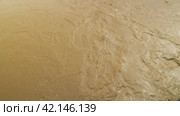 A view from above of the swift, muddy, gurgling water in the river. Flooding. A weather disaster. Natural disasters. Brown river carrying rubbish. Extreme weather. Стоковое видео, видеограф Воловодов Владимир / Фотобанк Лори