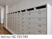 White steel Mailboxes in an apartment residential building inside. Modern rows of numbered mailbox, creative design mail backgrounds. Urban correspondence concept. Copy ad text space. Generated Ai. Стоковое AI-изображение, AI-художник Aleksandr Golubev / Фотобанк Лори