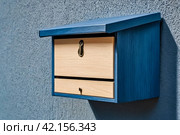 Blue wooden Mailboxes in an house residential building outside. Modern numbered mailbox box outdoors, creative design mail backgrounds. Urban correspondence concept. Copy ad text space. Generated Ai. Стоковое AI-изображение, AI-художник Aleksandr Golubev / Фотобанк Лори