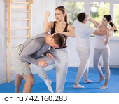 Woman hits man attacker on head during self-defense training session led by trainer. Стоковое фото, фотограф Яков Филимонов / Фотобанк Лори