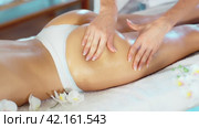 Closeup of hands of professional masseuse performing anti-cellulite massage on buttocks and thighs of young female client at spa center. Стоковое видео, видеограф Яков Филимонов / Фотобанк Лори