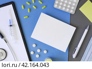 Empty gray modern doctor desk table with mask, notepad, syringe. Copy space, flat lay. Top view. Medicine and healthcare, cardiology, medical education. Blank space for text. Paper sheet for text. Стоковое фото, фотограф Марина Демидюк / Фотобанк Лори