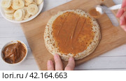 Spread thin pancakes with chocolate or cream paste. Pancakes with boiled condensed milk and banana filling. Стоковое видео, видеограф Глущенко Елена / Фотобанк Лори
