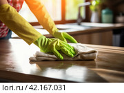 Woman Wearing Rubber Gloves Dusts Wooden Table in Kitchen. Стоковое AI-изображение, AI-художник Юлия Гапеенко / Фотобанк Лори