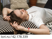 Девушка в белой футболке  лежит на полу закинув руки за голову. Стоковое фото, фотограф Elena Kotova / Фотобанк Лори
