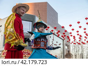 Празднование Китайского Нового года на ВДНХ в Москве. Крупным планом ходулисты на площади у колеса обозрения "Солнце Москвы" (2024 год). Редакционное фото, фотограф Наталья Николаева / Фотобанк Лори