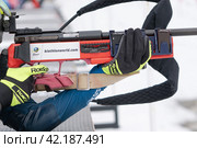 Sportswoman biathlete rifle shooting in prone position. Selective focus, extreme close-up shot. Biathlete in shooting area (2019 год). Редакционное фото, фотограф А. А. Пирагис / Фотобанк Лори