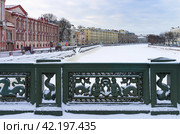 St. Petersburg in winter. View of the snow-covered Fontanka River and river embankments from Anichkov Bridge, decorated with cast iron fence with mermaids and seahorses on cold snowy winter day (2024 год). Стоковое фото, фотограф Виктория Катьянова / Фотобанк Лори