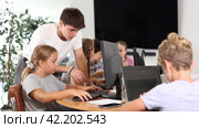 Guy teacher teaches girl student how to use computer. Стоковое видео, видеограф Яков Филимонов / Фотобанк Лори