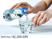 Женщина аккуратно наливает из пластиковой бутылки чистую воду в стеклянный стакан. Стоковое AI-изображение, AI-художник Щеголева Ольга / Фотобанк Лори