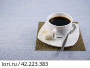 Белая чашка чёрного кофе с сахаром на салфетке-циновке и красивом блюдце на столе ранним утром. Стоковое фото, фотограф Владимир Устенко / Фотобанк Лори
