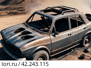 Completely burnt out and carbonized car. Vehicle blown up by military shell burned abandoned automobile during war operations. Copy ad text space. Стоковое AI-изображение, AI-художник Aleksandr Golubev / Фотобанк Лори
