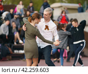 Moscow, Russia - May 9, 2022: Cheerful Dancing couple of young man and woman in public park. Lifestyle theme. Having fun people. People celevrate Victory Day, the win in the Great Patriotic War. Редакционное фото, фотограф YuryKara / Фотобанк Лори