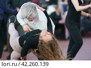 Moscow, Russia - May 9, 2022: Cheerful Dancing couple of young man and woman in public park. Lifestyle theme. Having fun people. People celevrate Victory Day, the win in the Great Patriotic War. Редакционное фото, фотограф YuryKara / Фотобанк Лори