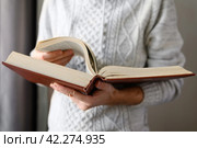 The man is leafing through a huge old book. Selective focus on the book. Стоковое фото, фотограф Никита Бурденков / Фотобанк Лори