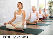 Young lady performs comfortable lotus asana-Padmasana-Siddhasana pose. Стоковое фото, фотограф Яков Филимонов / Фотобанк Лори