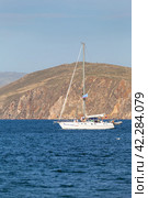 BAIKAL LAKE, SAKHYURTA VILLAGE, IRKUTSK REGION, RUSSIA - August 14, 2023: Tourists relax with their family on a pleasure sailing yacht and travel along the rocky shore of Olkhon Island. Summer holiday on Baikal Lake. Редакционное фото, фотограф Виктория Катьянова / Фотобанк Лори