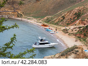 BAIKAL LAKE, OLKHON ISLAND, KHUZHIR VILLAGE, IRKUTSK REGION, RUSSIA - August 16, 2023: A modern fishing motorboat with tourists returns from travels and fishing to the beach of Khuzhir Bay. Редакционное фото, фотограф Виктория Катьянова / Фотобанк Лори