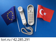 Flag of the European Union, Turkey and an old corded telephone on a blue background, concept on the topic of telephone conversations between countries. Стоковое фото, фотограф Сергей Чайко / Фотобанк Лори
